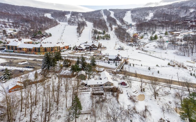 Aerial view of Condos at the Creek in winter, surrounded by snow-covered forest