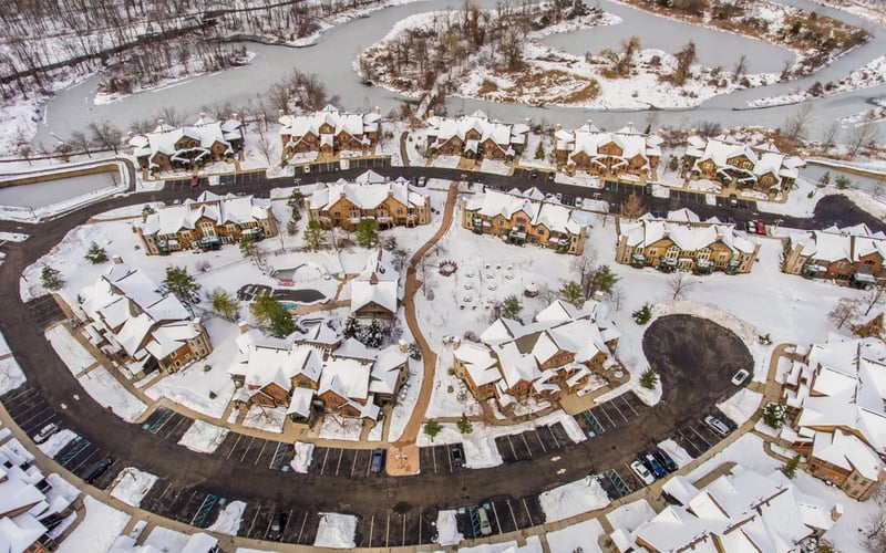 Aerial winter view of the condo community with curved streets and snow-covered rooftops