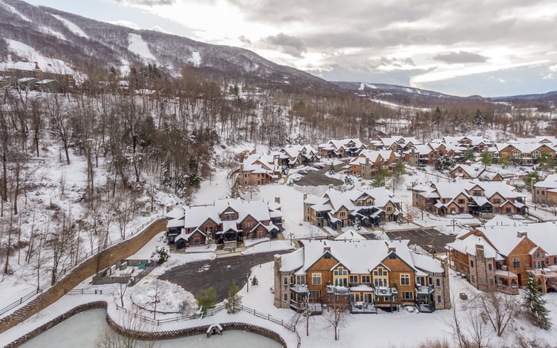Aerial winter view of the condo community with ski slopes visible in the background