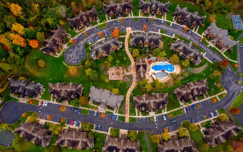 Aerial view of circular residential neighborhood with central pool and surrounding homes